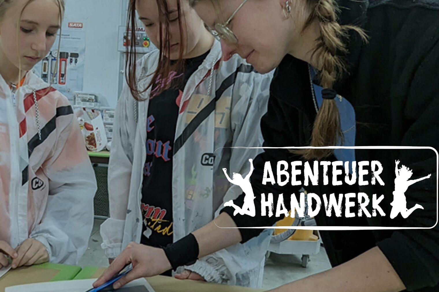 Ausbildungsmeisterin zeigt jungen Mädchen, wie sie eine Folie luftblasenfrei auf eine Scheibe anbringen. Ausbildungsmeisterin zeigt jungen Mädchen, wie sie eine Folie luftblasenfrei auf eine Scheibe anbringen.
