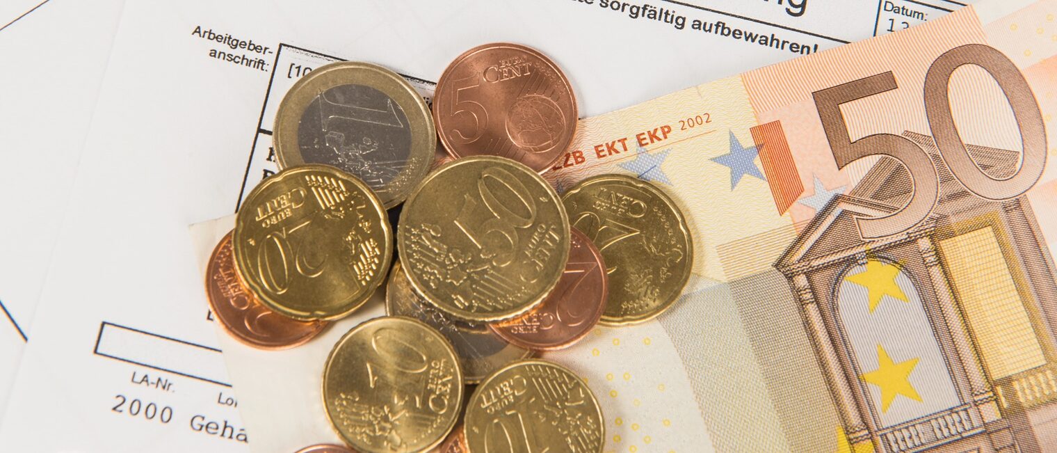 Lohnabrechung mit daraufliegendem Bargeld