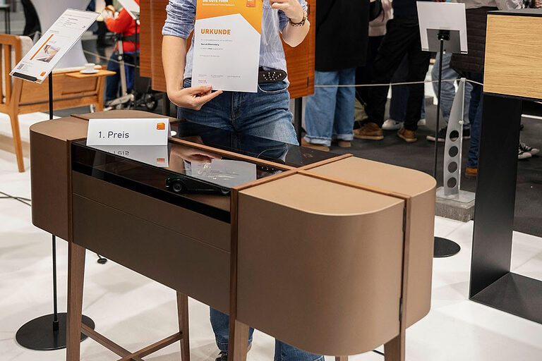 Hannah Bronneberg hat für das diesjährige Siegerstück Nussbaumholz, Bronzelack, Leder und getöntes Glas gekonnt miteinander kombiniert.