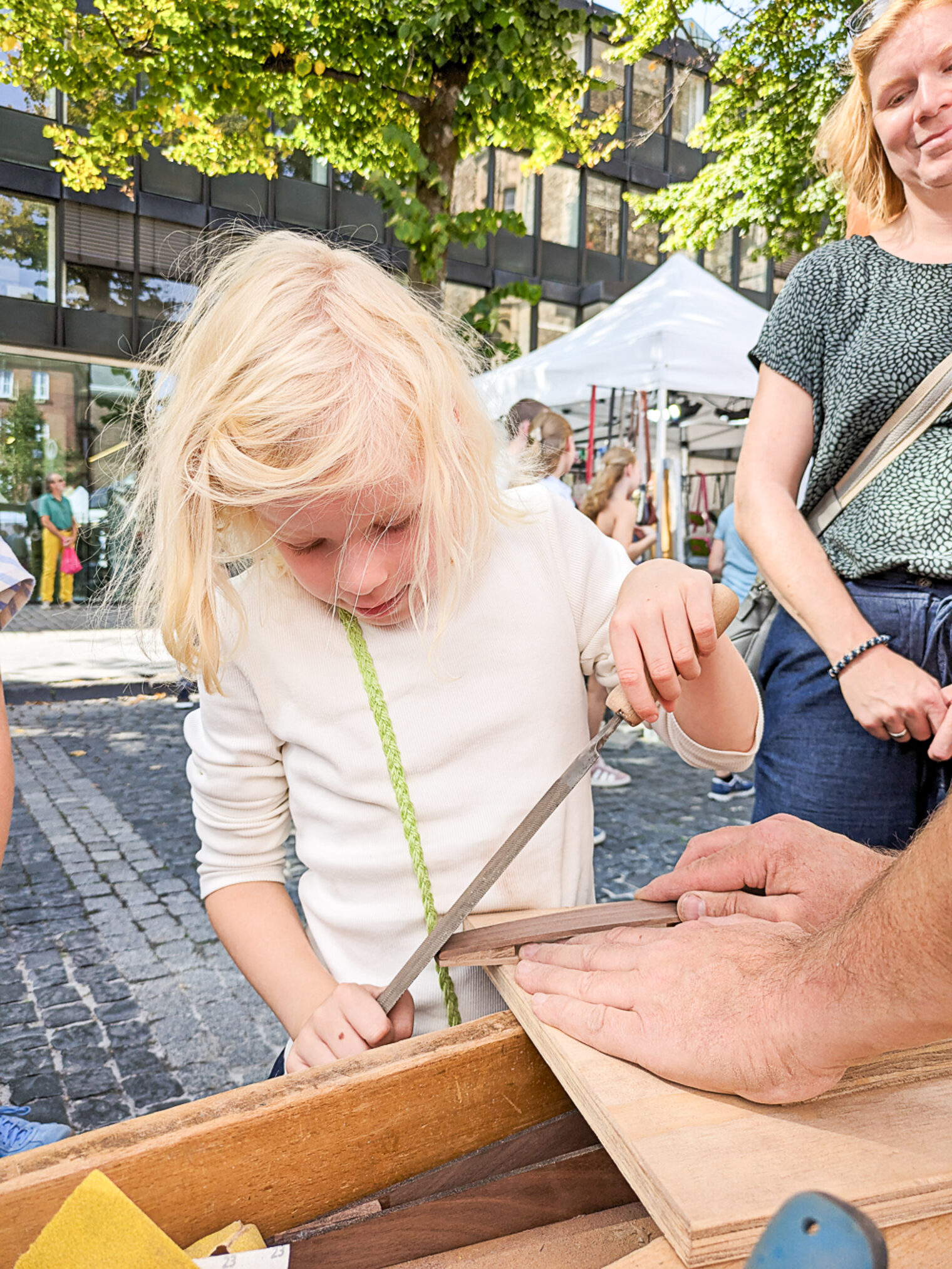 Junges Mädchen schleift Holz auf dem Europamarkt 2025 in Aachen